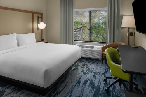a hotel room with a bed and a desk and a window at Fairfield by Marriott Inn & Suites Stockton Lathrop in Lathrop