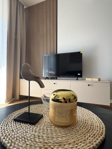 a living room with a table with a bird statue and a television at Petra in Stara Pazova