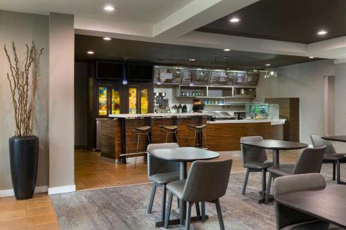 a restaurant with tables and chairs and a bar at Courtyard St. Louis Airport/Earth City in Bridgeton