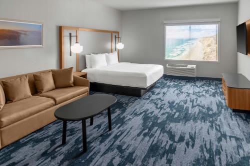 a hotel room with a bed and a couch at Fairfield by Marriott Inn & Suites San Francisco Pacifica in Pacifica