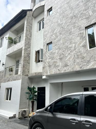 a car parked in front of a building at Luxury 1&2 Bedrooms Apartment Ikeja Lagos Core, Family, Business, Leisure, 24h Power&Water, Fast WiFi, Two Balconies, Spacious Living, Easy Transport,Just 10min to GRA&SHOPRITE in Ikeja
