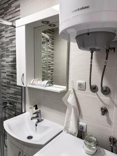 a bathroom with a white sink and a mirror at Limpio Apartman 2 in Belgrade