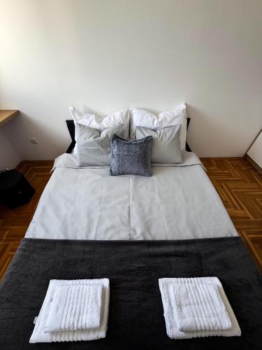 a large bed with two pillows and two towels on it at Limpio Apartman 2 in Belgrade