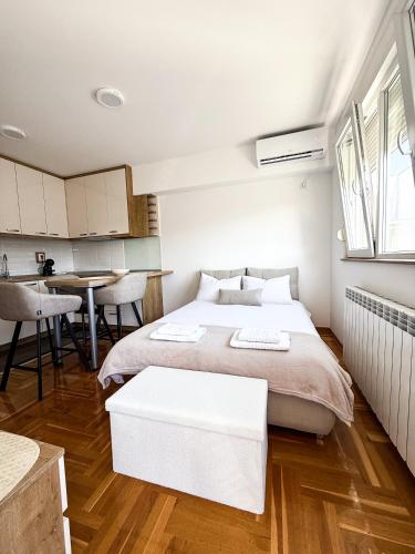 a bedroom with a large bed and a table at Limpio Apartman 2 in Belgrade