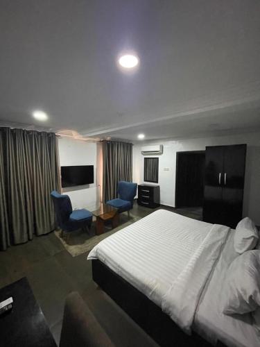 a hotel room with a bed and two blue chairs at Noah's Ark Hotel & Suites in Maroko