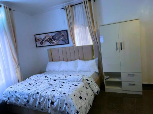 a bedroom with a bed and a dresser at Luxury 1&2 Bedrooms Apartment Ikeja Lagos Core, Family, Business, Leisure, 24h Power&Water, Fast WiFi, Two Balconies, Spacious Living, Easy Transport,Just 10min to GRA&SHOPRITE in Ikeja