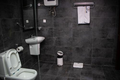 a bathroom with a toilet and a sink at Noah's Ark Hotel & Suites in Maroko