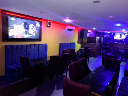 a room with chairs and tables and a large screen at Noah's Ark Hotel & Suites in Maroko