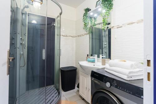 a bathroom with a shower and a washing machine at Bel appartement au calme et cosy à deux pas de la plage in Le Gosier