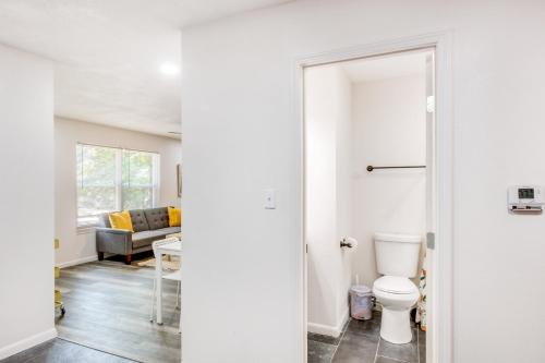 a bathroom with a toilet and a living room at Pet-Friendly Overland Park Condo with Pool Access! in Overland Park