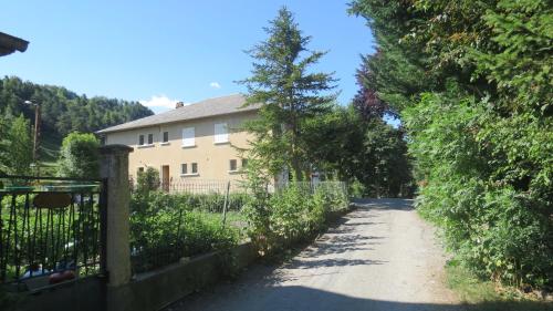 une maison avec un arbre sur le côté d'une route dans l'établissement Camping la Tour, à Embrun