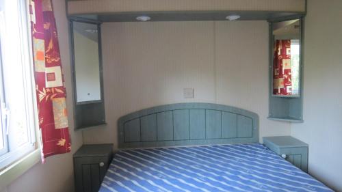 une chambre avec un lit avec une couette bleue dans l'établissement Camping la Tour, à Embrun