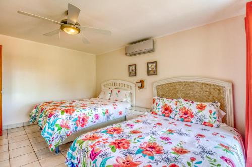 a bedroom with two beds and a ceiling fan at Bahia Pez Vela Villa at 18 in Ocotal