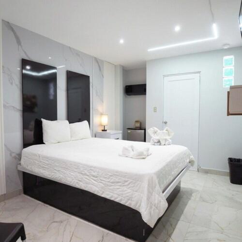 a bedroom with a large white bed in a room at Hotel Vista Verde in Yauco