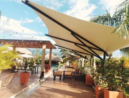 a patio with umbrellas and tables and chairs at VillaFatima in Rivera