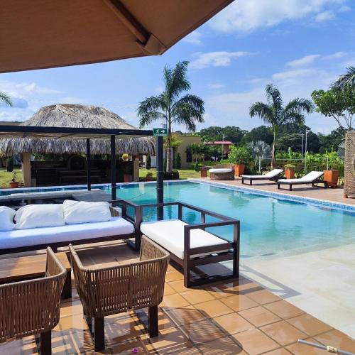 a pool with two beds and a table and chairs at VillaFatima in Rivera