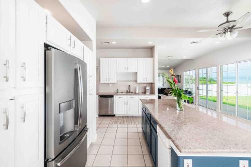 a kitchen with white cabinets and a stainless steel refrigerator at Northshore Oceanfront Home- 5 bedroom and 4 bath in Waialua