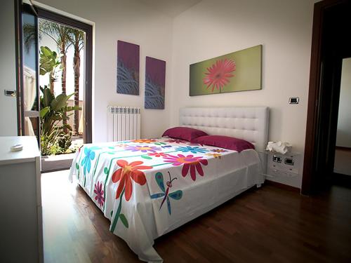 Un dormitorio con una cama blanca con flores. en Appartamento Paolo, en Lecce