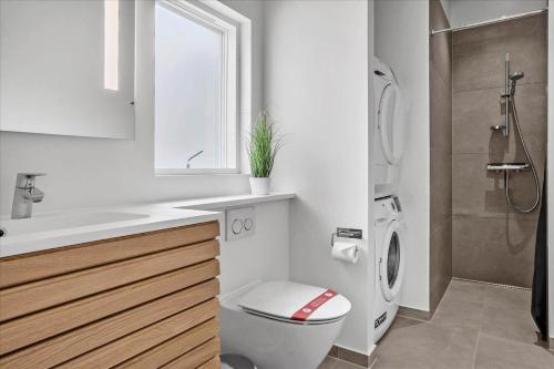 a white bathroom with a toilet and a sink at BV208-Blavand-Strandparken-16 in Blåvand