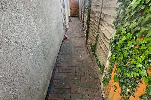a brick pathway leading to a building with a plant at 4-Bed Barnwell Retreat- Sleeps 9 Garden & Parking in Stevenage