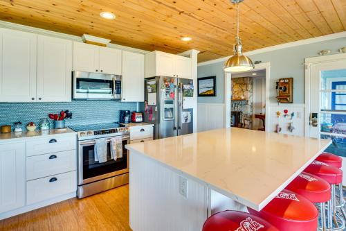 a kitchen with white cabinets and a counter with red stools at Across Water From Belfair SP Hood Canal Cottage! in Belfair