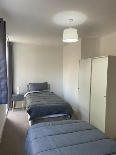 a row of beds in a room with a lamp at Channel View Apartment Barry Waterfront in Barry