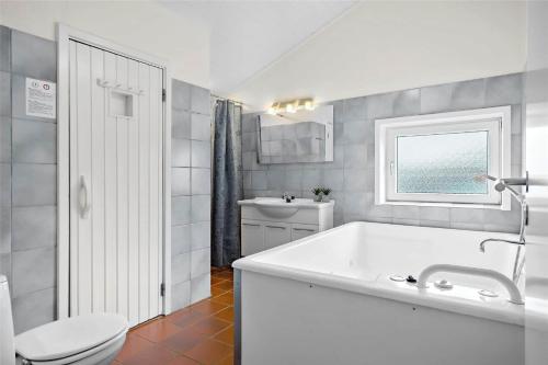 a bathroom with a tub and a toilet and a sink at BV117-Vejers-Strand-Engesovej-34 in Vejers Strand