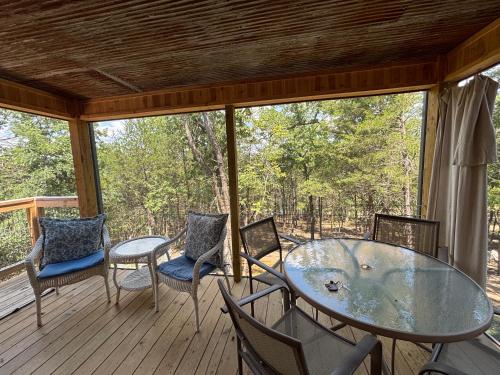 a screened porch with a glass table and chairs at Liberty Loft in Eagle Rock