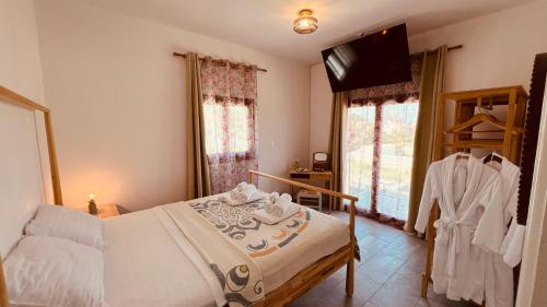 a bedroom with a bed and a flat screen tv at First Eco-Villa in Polis Chrysochous