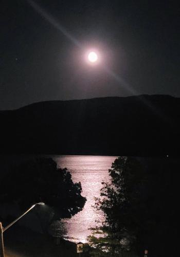 a moon rising over a body of water at night at Premium Deluxe PeachView Suites 3BR in Peachland