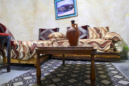 a living room with a couch and a vase on a table at كهوف يحيى للسياحة والمبيت البهاليل in Bhalil
