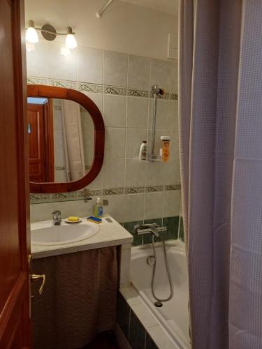 a bathroom with a sink and a tub and a mirror at CHARMING studio proche centre in Castellane