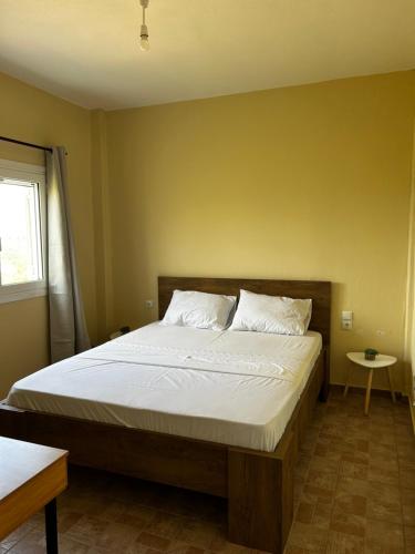 a bedroom with a large bed with white sheets at Sellas Retreat in Patra