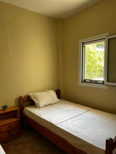 a bedroom with a bed and a window at Sellas Retreat in Patra