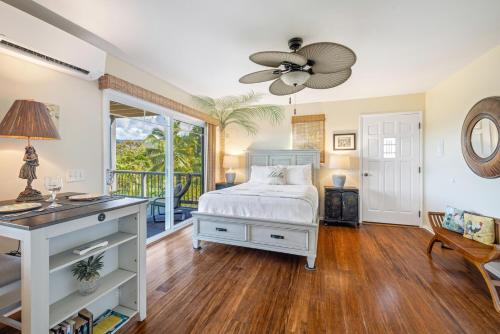 a bedroom with a bed and a desk and a window at Marjorie's Kauai Inn in Lawai