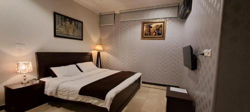 イスラマバードにあるTourist Haven Guesthouse, Islamabadのベッドとテレビがあるホテルの部屋