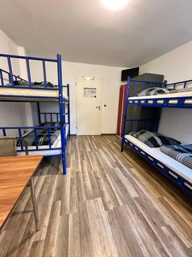 a room with two bunk beds and a table at Hostel Pinneberg in Pinneberg