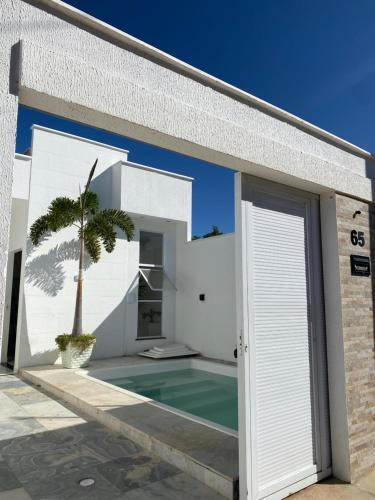 a white house with a swimming pool and a door at casa blanca in Beberibe