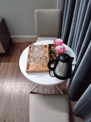 a table with a tea kettle and a tray of food on it at Hotel LOAN ĐÀI in Bùi Tiếng