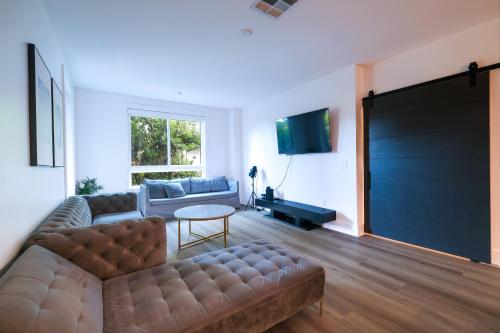 a living room with a couch and a tv at Multiple Hollywood Apartments Hub in Los Angeles
