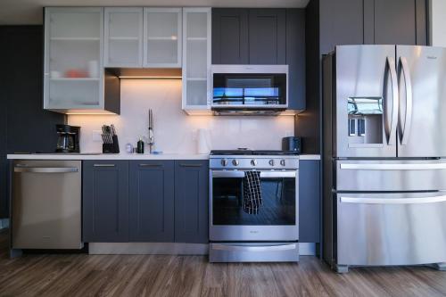 a kitchen with white cabinets and a stainless steel refrigerator at Multiple Hollywood Apartments Hub in Los Angeles