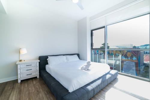 a bedroom with a bed and a large window at Multiple Hollywood Apartments Hub in Los Angeles