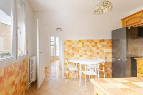 a kitchen with a table and chairs in a room at appartement proche paris et Roissy in Persan