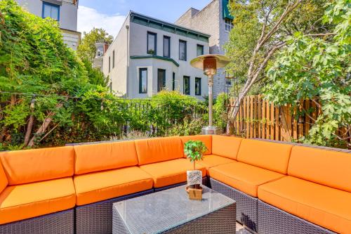 an orange couch on a patio with a table at Walk to Hudson River Parks Recently Renovated Apt in Hoboken