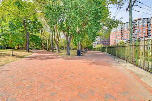 a brick path in a park with trees and buildings at Walk to Hudson River Parks Recently Renovated Apt in Hoboken