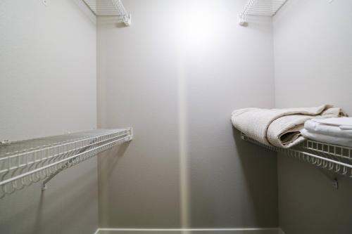 a white bathroom with a shower and white towels at Multiple Hollywood Apartments Hub in Los Angeles