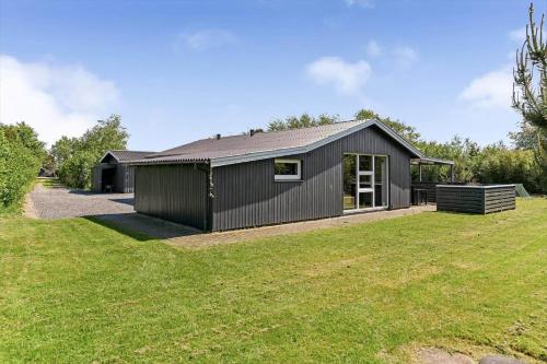 a black house with a large yard at BV302-Blavand-Gronnevej-12 in Blåvand