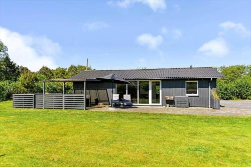 a small grey house with a large yard at BV302-Blavand-Gronnevej-12 in Blåvand