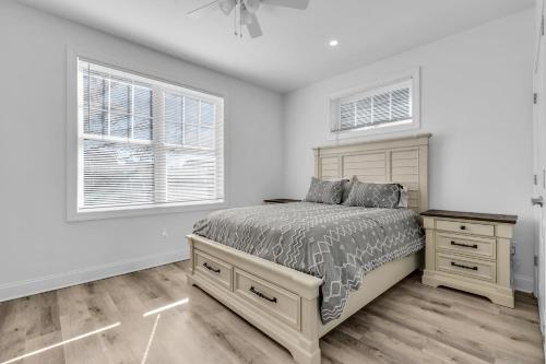 a white bedroom with a bed and two windows at Best 4br Home Great Kitchen, Wifi, Parking For 3 in Seaside Heights
