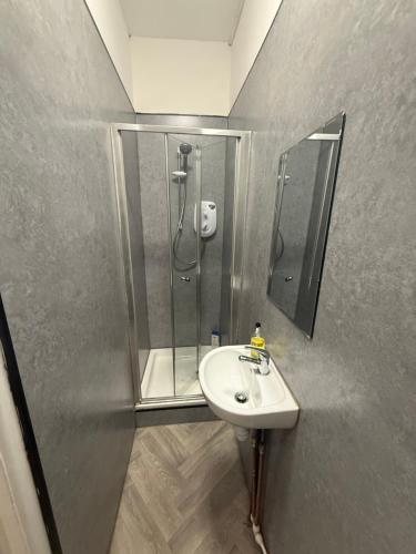 un baño con lavabo y ducha en Premier Apartmetns Manchester, en Mánchester